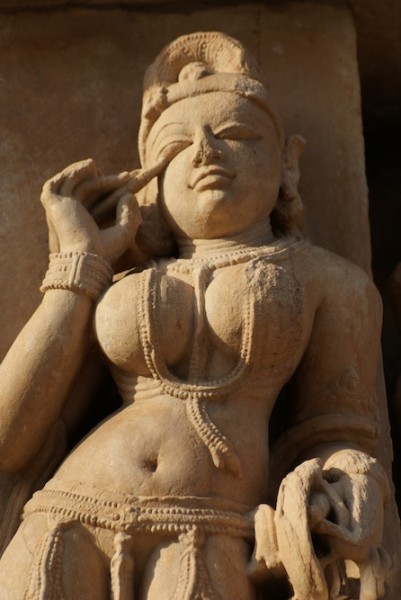 Khajuraho carving of a woman applying make up - carved 1000 years go!