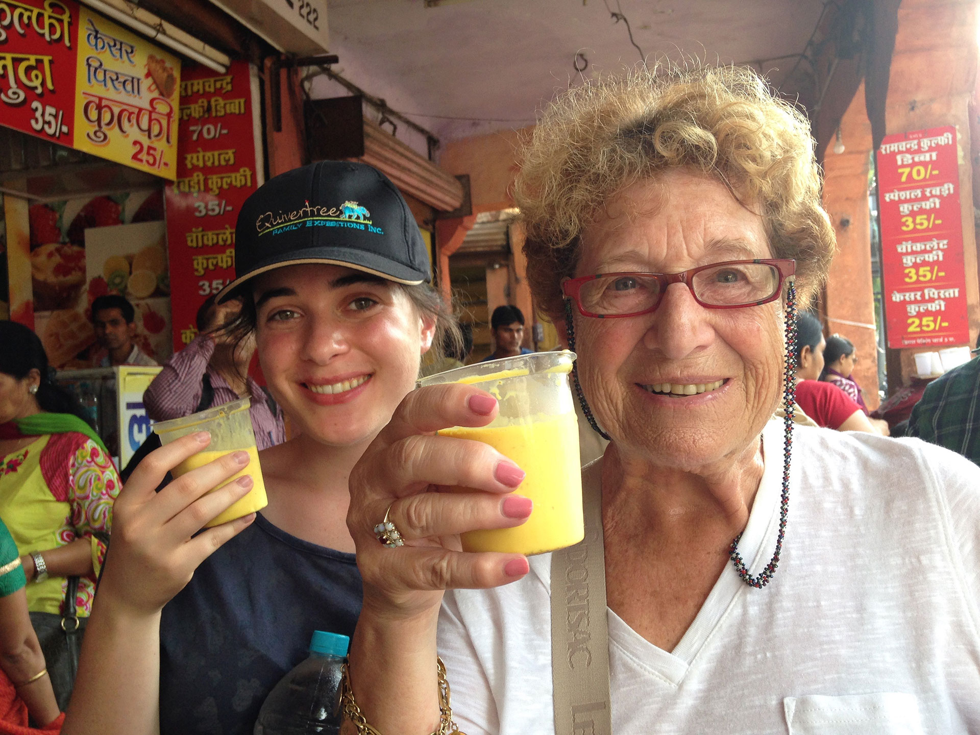 two female tourists drinking fresh squeezed mango in india