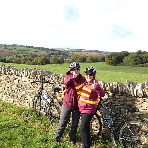 two woman with thumbs up on biking trip