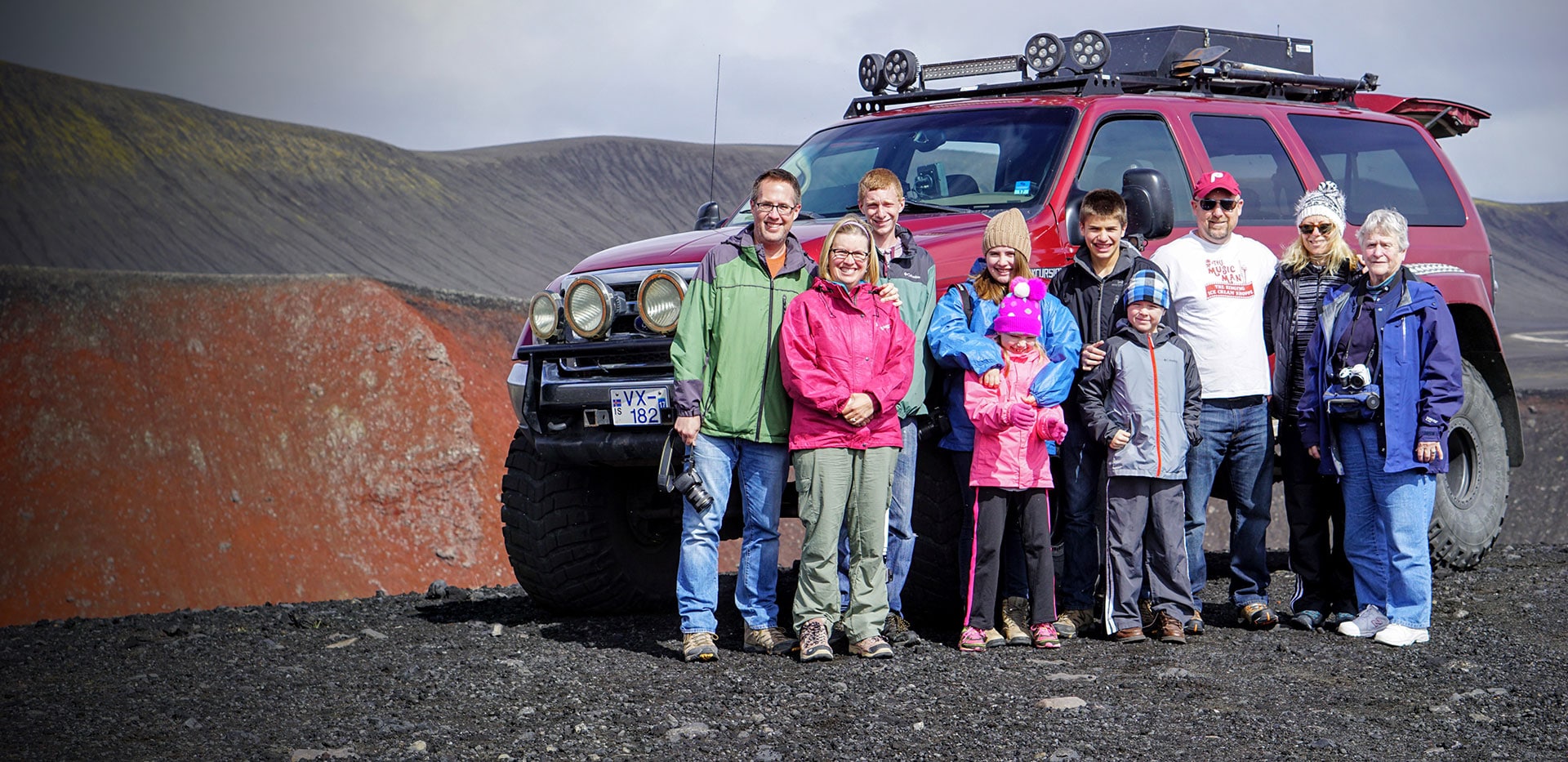 family in front of truck in iceland