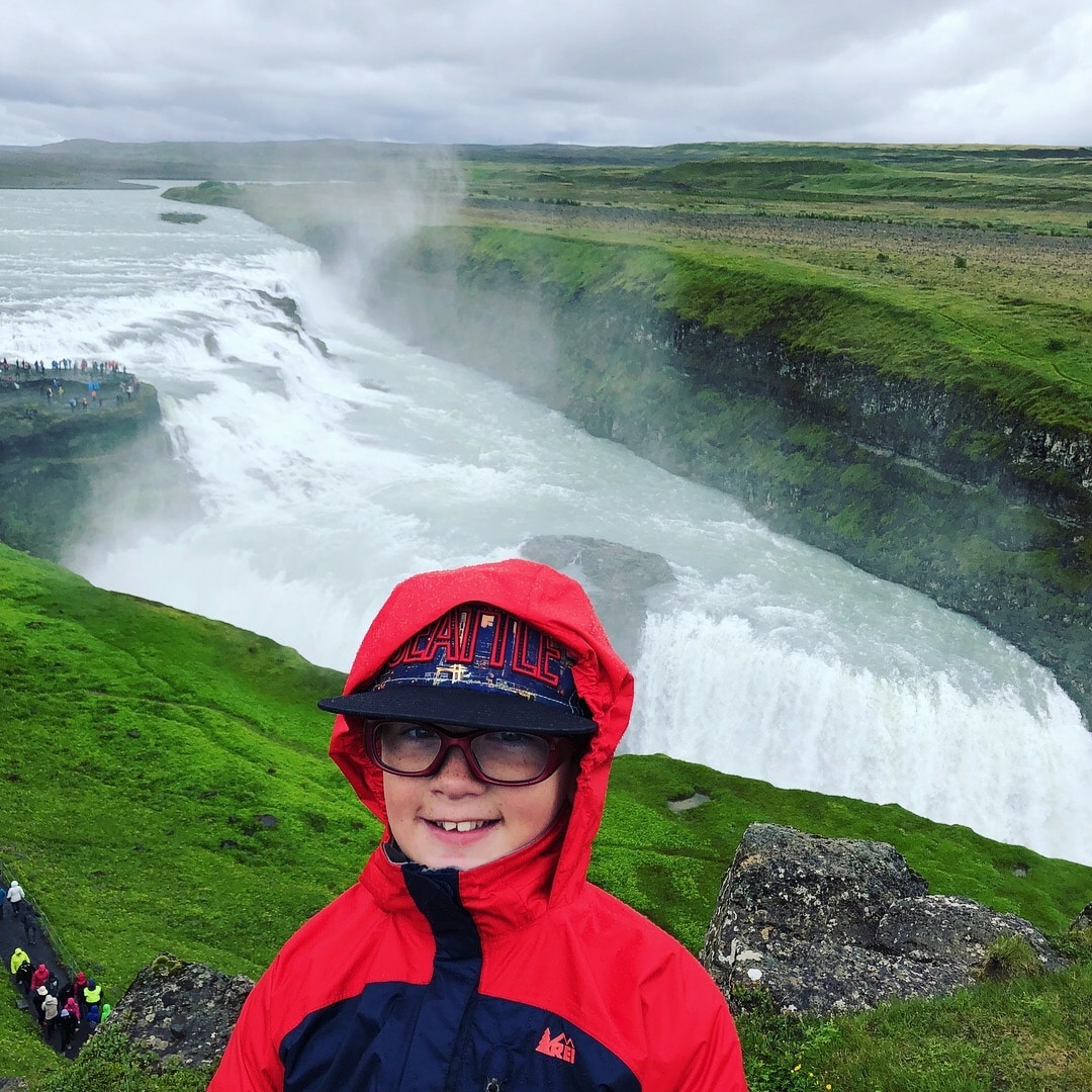 boy in front of waterfall in iceland