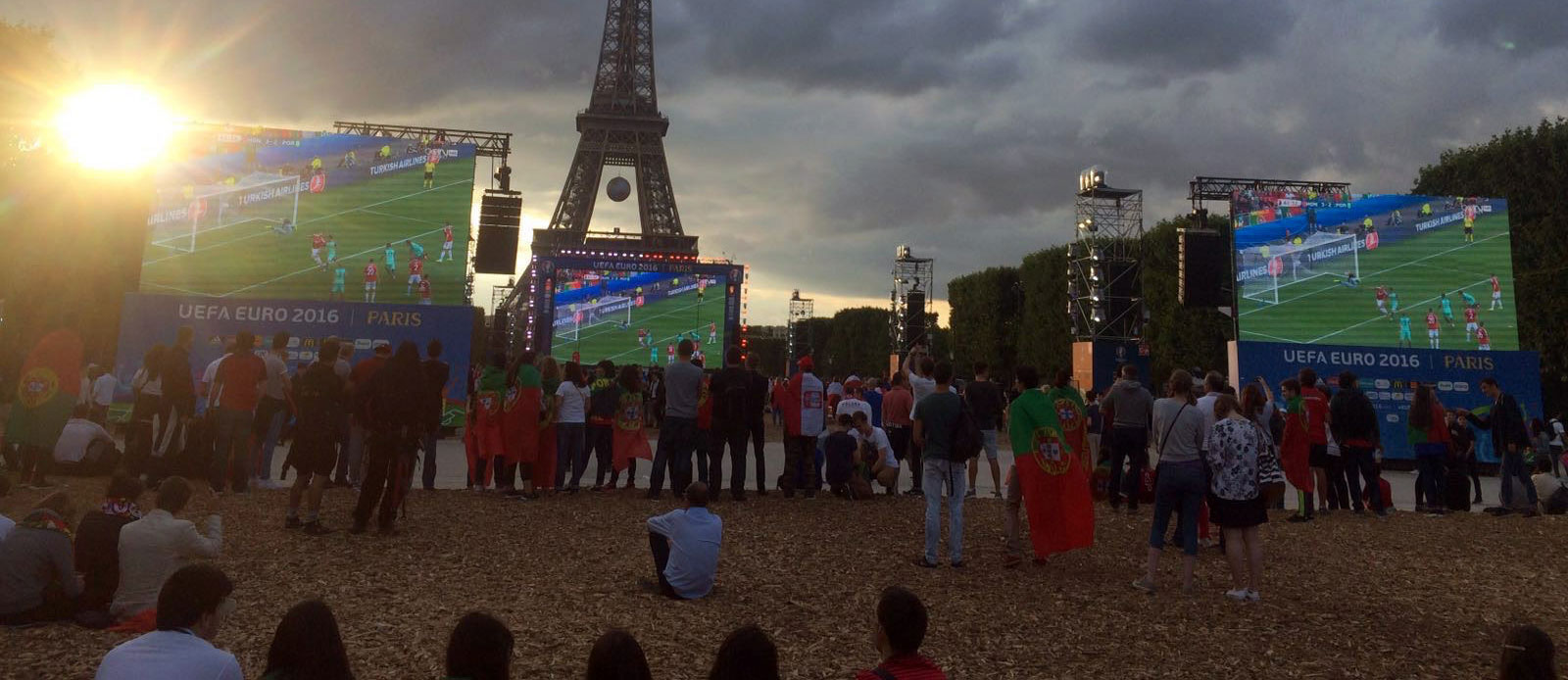screens playing soccer match in front of Eiffel Tower